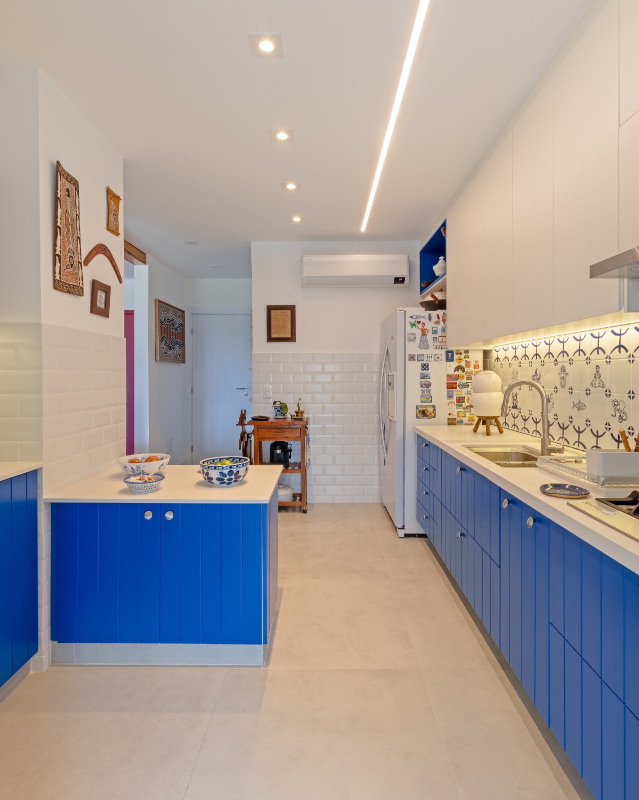 Passagem entre a cozinha e o hall de entrada, marcenaria azul laqueada